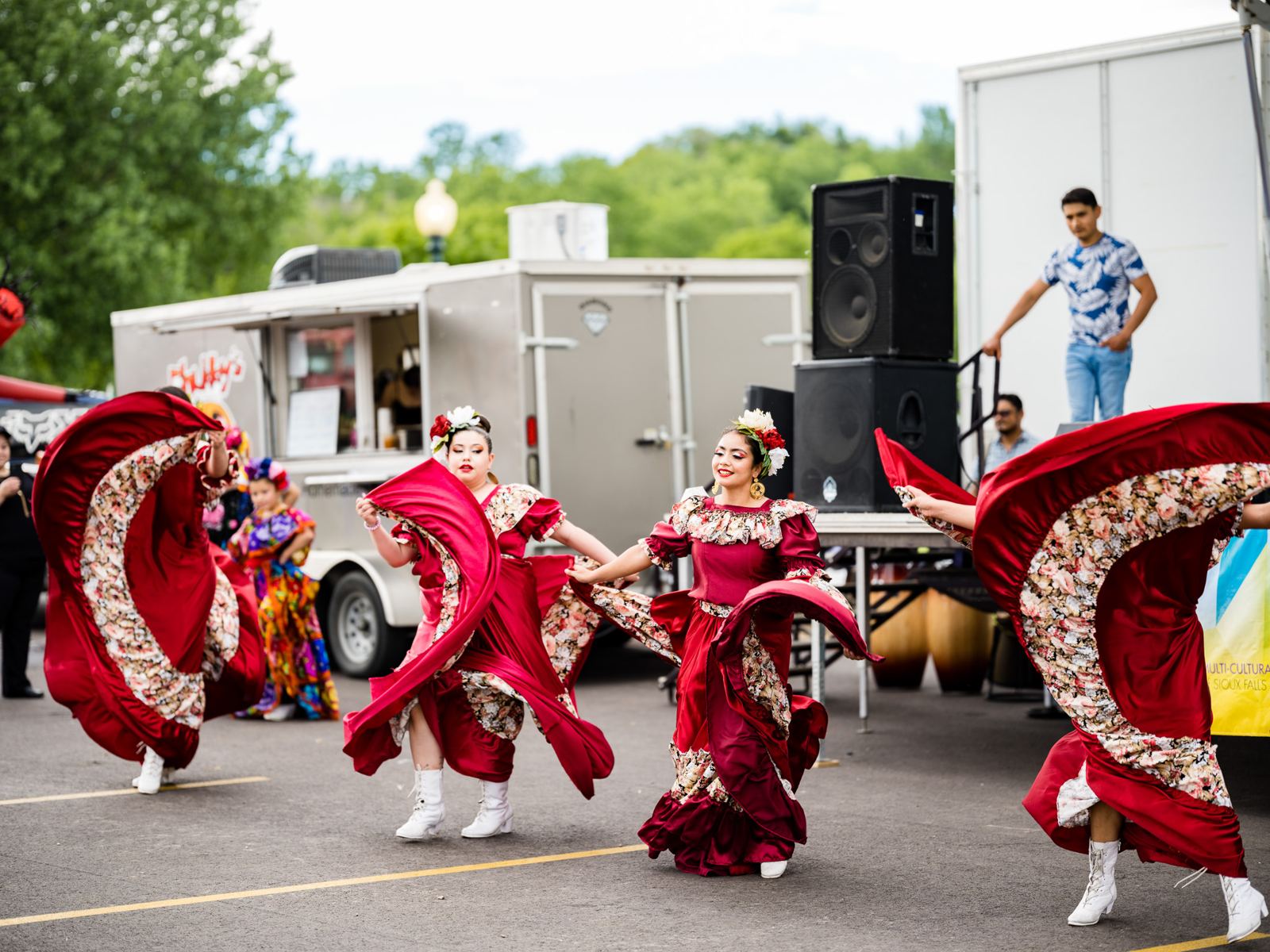 Folklorico dancers in red dresses performing at a Sioux Falls festival