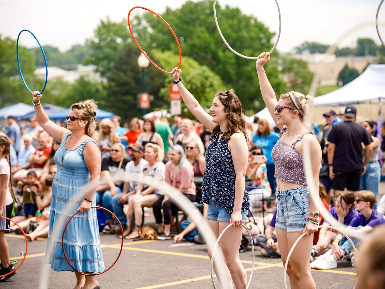 Festival goers raising hula hoops at a summer event downtown