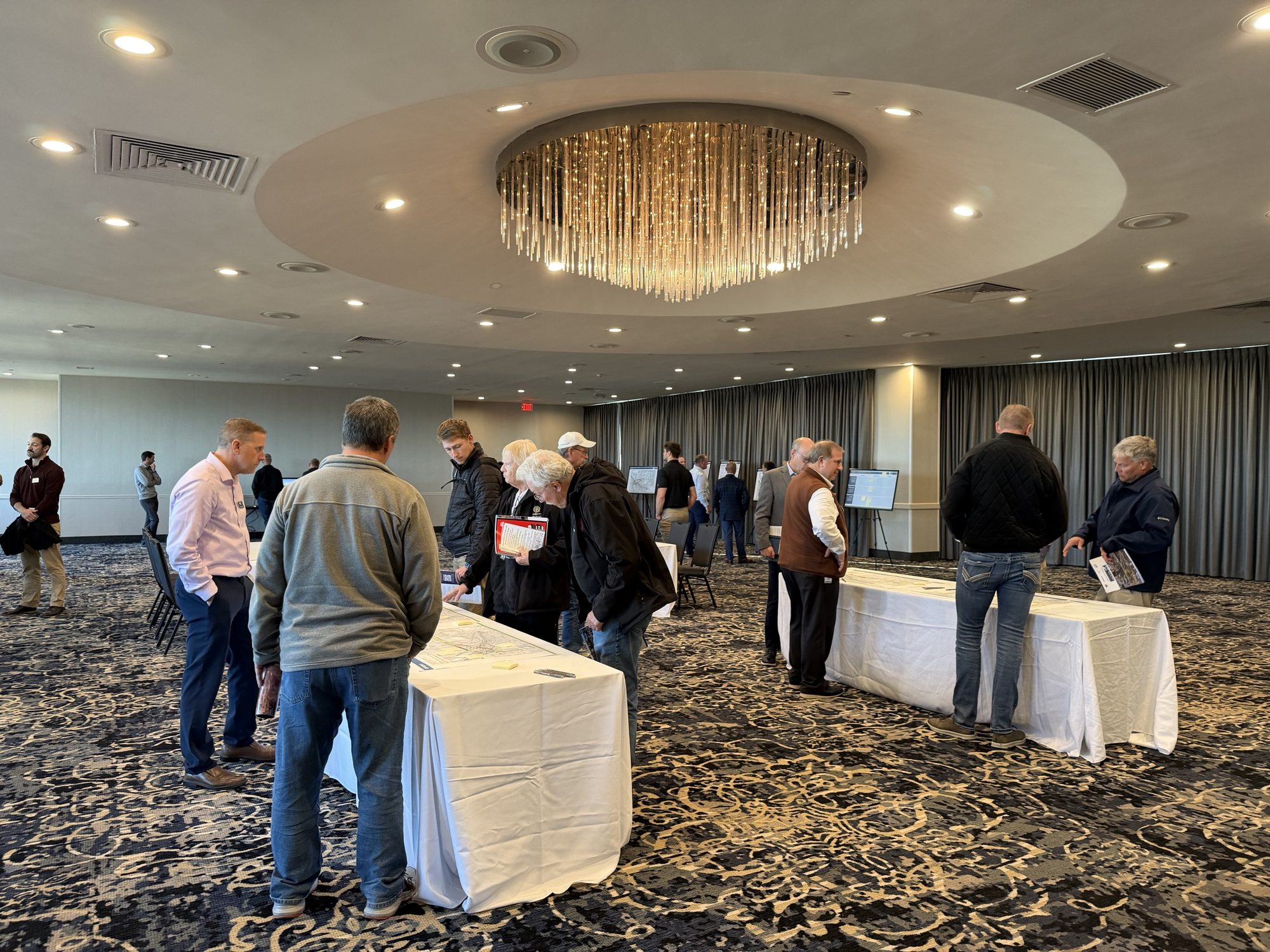 People look over printed maps of the viaduct options on tables in a ballroom at the Holiday Inn City Centre
